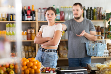 Married couple had an argument while choosing groceries in a store. Couple arguing in store with...