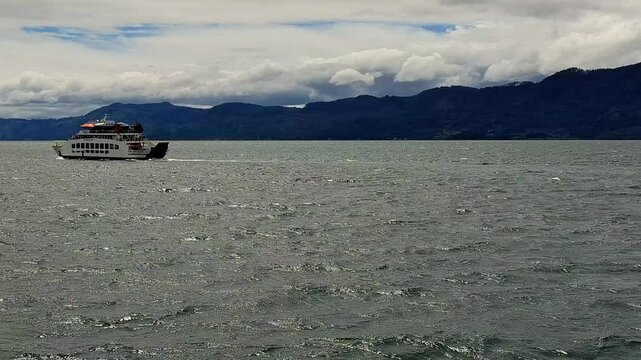 View of the KMP Pora pora ferry sailing on Lake Toba with small waves. Domestic ferry with a fixed route on lake waters. Sailing from Samosir to Parapat and vice versa.