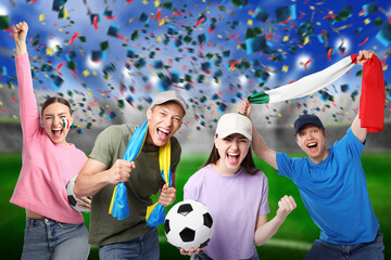 Excited football fans under falling confetti at stadium