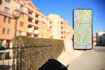 Man looking at city map on his mobile phone outdoors, closeup