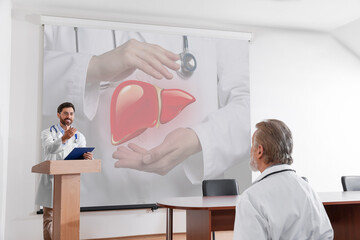 Healthcare professional giving lecture about liver in conference room using video projector....