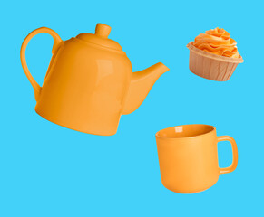 Orange teapot, cup and cupcake in air against light blue background