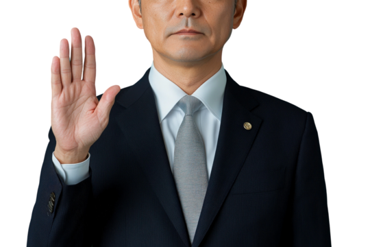Business professional with raised hand giving an oath or promise, formal attire in a studio setting, serious expression with isolated background