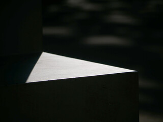 trianglular shape of a metall surface shining in sunlight and black background