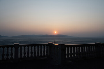 View from a terrace with column railing to the sea  at sunset