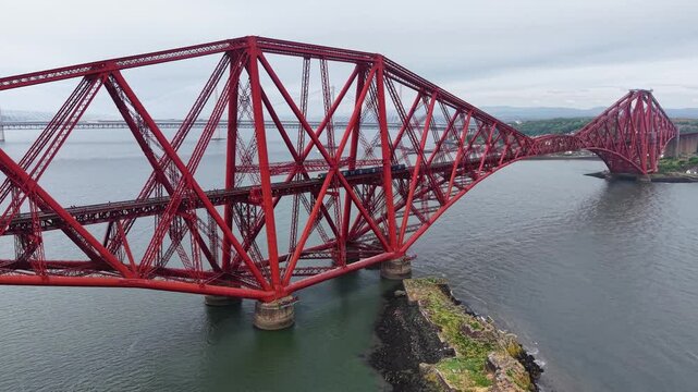 Aerial footage of train crossing Forth Bridge, Scotland, United Kingdom