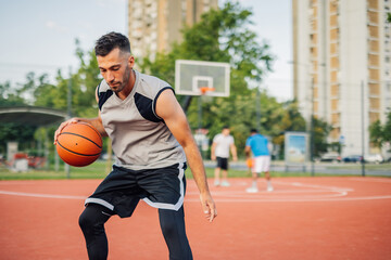Basketball player dribbling and preparing to shoot ball on court