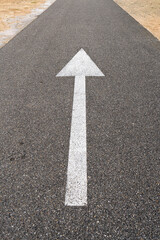 arrow straight ahead on asphalt road