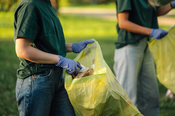 Volunteers collecting garbage in park wearing gloves