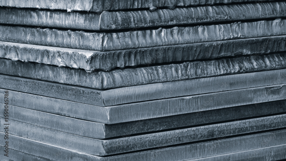 Poster stack of dark blue thick heavy metal plates rusty uneven surface after laser cutting. plates stacked
