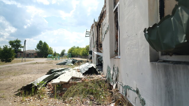 A bombed school with playground on background in the Izum, Ukraine