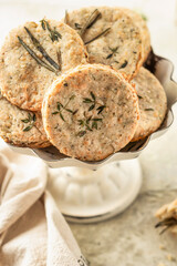 Shortbread cheese cookies with aromatic herbs on rustic textured background close up. Savory parmesan cookies for party
