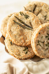 Shortbread cheese cookies with aromatic herbs on rustic textured background close up. Savory parmesan cookies for party