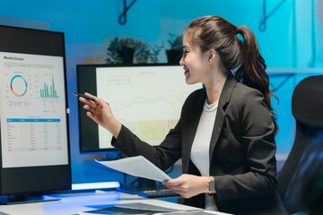 Businesswoman Analyzing Financial Data on Computer Screens