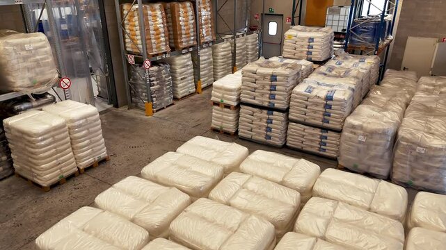 Tilting of large warehouse with pallets and shelves with bags of food products. Storage of cargo according to international standards. High angle view. No people