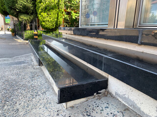 Steps, stairs, modern black stone steps outside building, staircase is finished with glossy tiles and contrasting light inserts