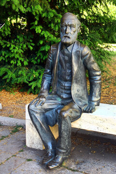 Jena, Germany - June 22, 2025: Bronze statue of seated Ernst Abbe on a bench in front of Zeiss Planetarium in Jena, Thuringia