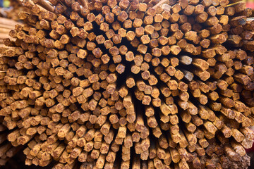 Stacked steel rods are prominently observed at a bustling construction site in progress