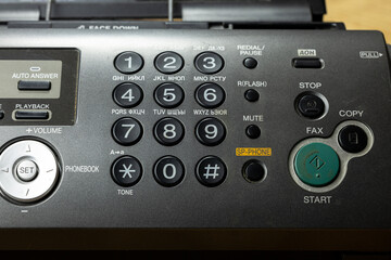 A close-up of a retro telephone with an answering machine. The device features a numeric keypad,...