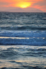 Wave splash at sunset close up. Ocean water in sunlight in motion. Abstract sea background