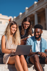 University students collaborating and learning together on campus steps