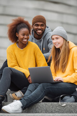 University students collaborating and learning together on campus steps