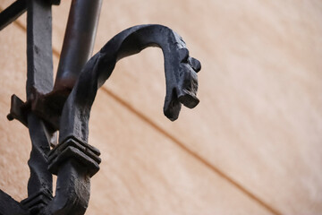 Wrought iron details of mythological dragon on window grill