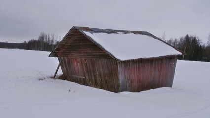 Swedish winter landscape with lots of snow and blue sky and traditional red and white houses in a rural scene