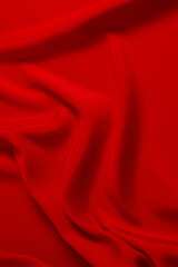 Red silk or satin luxury fabric texture can use as abstract background. Top view.
