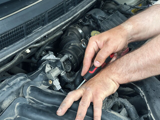 Car engine repair maintenance mechanic working with screwdriver tool on vehicle motor, automotive service.