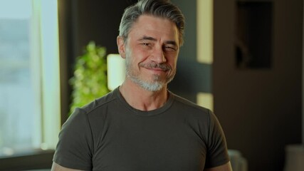 Happy smiling mature man standing in his modern living room at home. Portrait of confident fit muscular mid adult older male in 50s. - Powered by Adobe