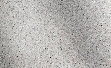 Abstract background. Texture of gray concrete or plaster with small inclusions and soft shadow.
