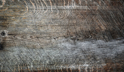 Texture of old, weathered wooden surface with knots and cracks.