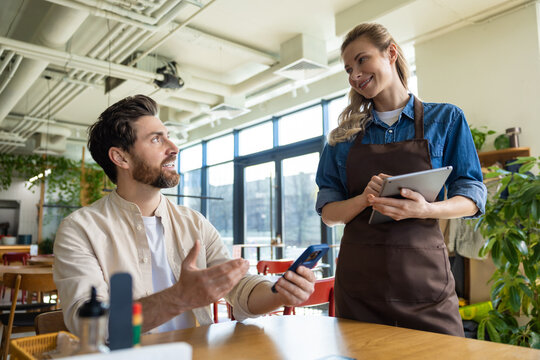 Man discussing order with waiter at restaurant