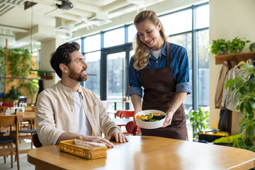 Man receiving salad from waiter at restaurant