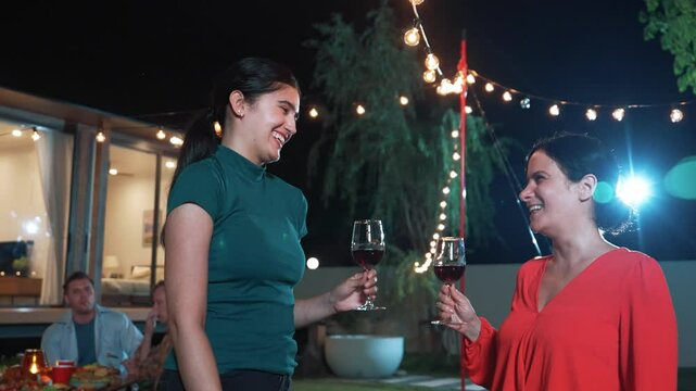 Family celebrate holiday. Mother and grandmother drink wine while father, grandfather and girl have dinner party food. Outdoor activity to spend time with relatives cross generation gap. Divergence.