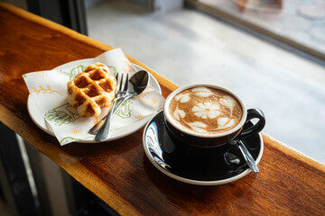 Hot coffee latte with latte art milk foam in cup mug and Homemade Belgian Waffles with honey on...