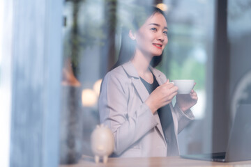 Portrait of beautiful happy Smiling  of hands Holding cup mug of Hot coffee latte wits business female casual working with laptop computer in coffee shop like the background,communication concept