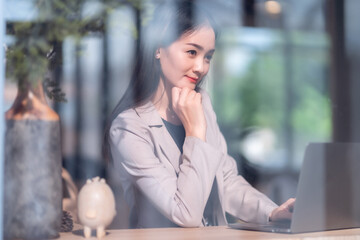 Asian freelance people business female talking making using casual working with laptop computer and coffee at home in the living room indoors artificial rose bouquet of red and pink roses rose vase