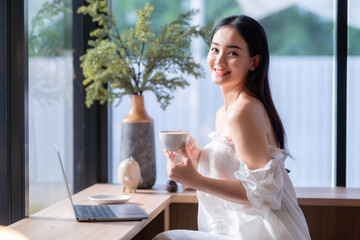 Portrait of beautiful happy Smiling  of hands Holding cup mug of Hot coffee latte wits business female casual working with laptop computer in coffee shop like the background,communication concept
