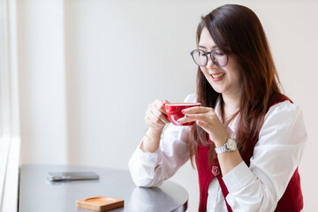 Close-up beautiful happy Smiling of hands Holding cup mug of Hot coffee latte wits business female in coffee shop like the background, communication concept