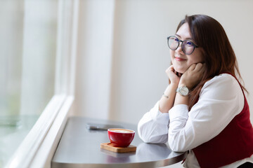 Close-up beautiful happy Smiling of hands Holding cup mug of Hot coffee latte wits business female in coffee shop like the background, communication concept