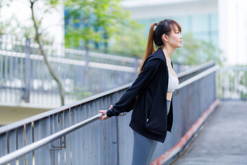 Portrait of beautiful asian Young woman in Black robe sportswear working out outside. training on public equipment in outdoor at park. concept Exercise Healthy lifestyle.