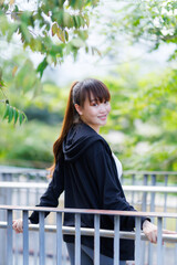 Portrait of beautiful asian Young woman in Black robe sportswear working out outside. training on public equipment in outdoor at park. concept Exercise Healthy lifestyle.