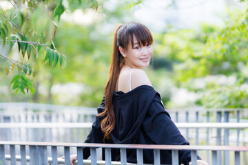 Portrait of beautiful asian Young woman in Black robe sportswear working out outside. training on public equipment in outdoor at park. concept Exercise Healthy lifestyle.