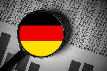 German economy analysis concept. Germany flag under magnifying glass. Financial report and chart background. Macro economic audit idea. Business growth and finance research related to Germany.