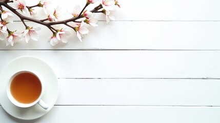 A serene scene of a neatly placed teacup, a delicate branch with blossoms, and a pristine white backdrop.
