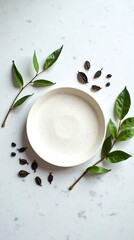 A minimalist white plate adorned with organic green leaves.