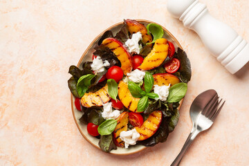 Top view of Summer peach caprese salad with tomatoes, basil, burrata cheese. Copy space.