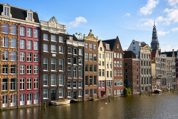 Damrak Dancing Houses in Sunshine Amsterdam Netherlands. Amsterdam's famous Damrak Dancing houses and canal reflections on a sunny day.

